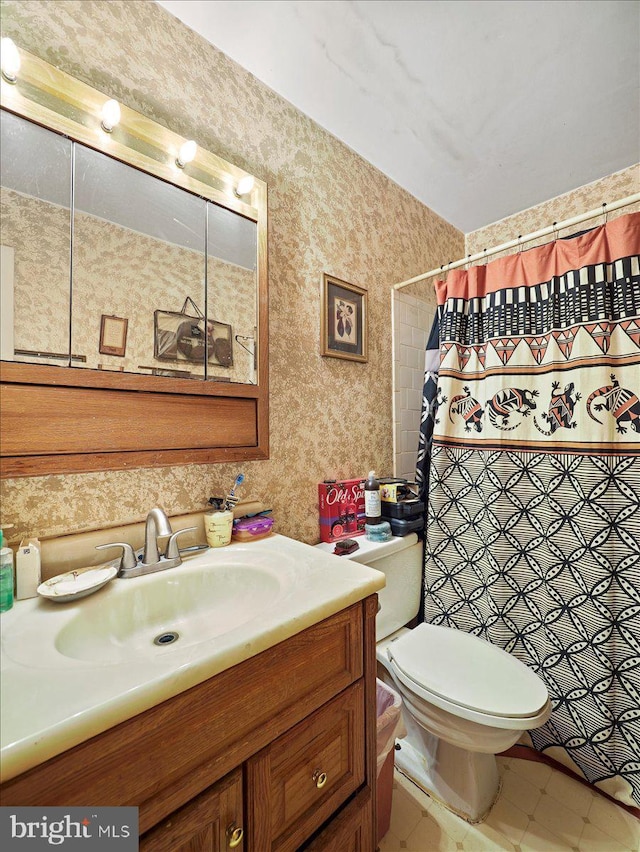 bathroom featuring toilet, vanity, tile patterned flooring, and walk in shower