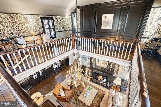 living room featuring a glass covered fireplace, stairway, hardwood / wood-style floors, and wallpapered walls