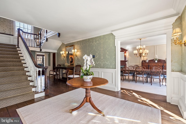 interior space featuring a chandelier, a wainscoted wall, stairs, hardwood / wood-style floors, and wallpapered walls