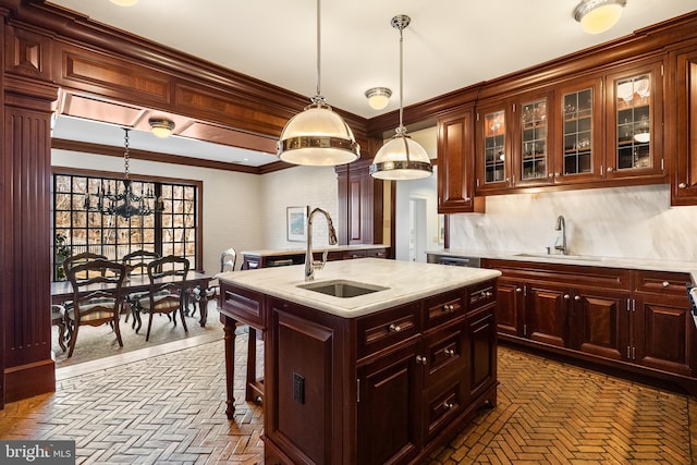 kitchen with ornamental molding, a sink, and decorative light fixtures