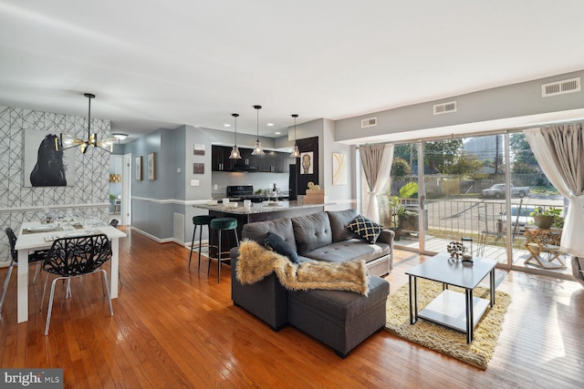 living room with wood-type flooring and an inviting chandelier