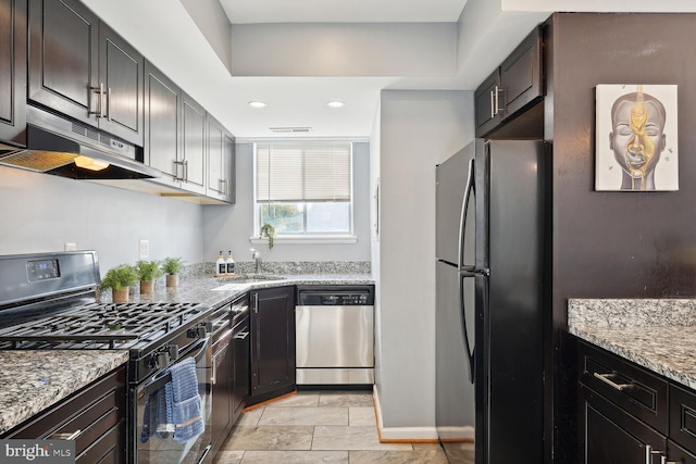 kitchen with sink, light stone counters, dark brown cabinetry, and black appliances