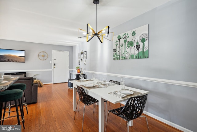 dining space with hardwood / wood-style flooring and an inviting chandelier