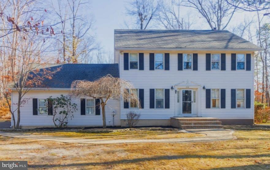 colonial-style house featuring a front yard