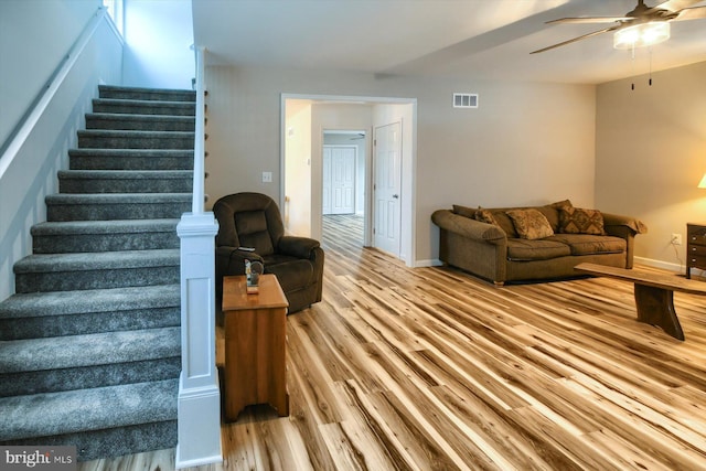 living room featuring light hardwood / wood-style flooring and ceiling fan