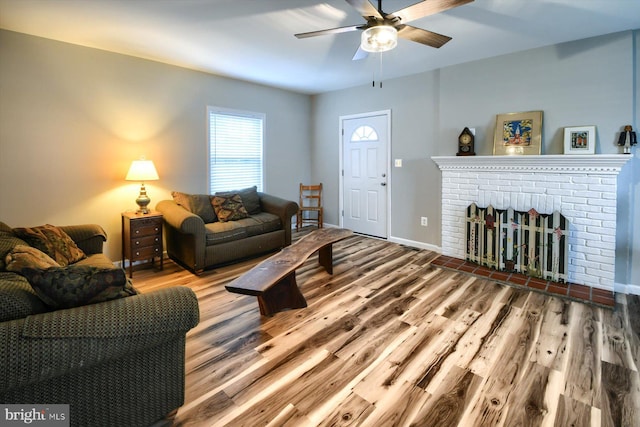 living room featuring ceiling fan, a fireplace, and hardwood / wood-style floors