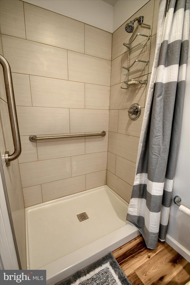 bathroom with curtained shower and hardwood / wood-style flooring