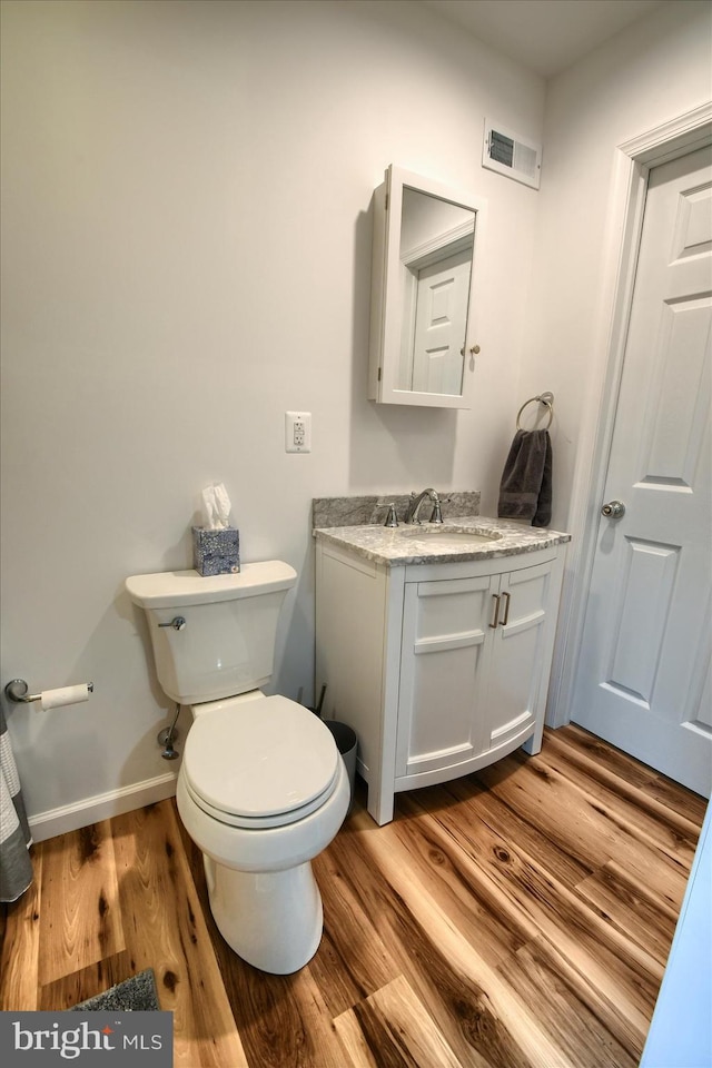 bathroom with vanity, hardwood / wood-style flooring, and toilet