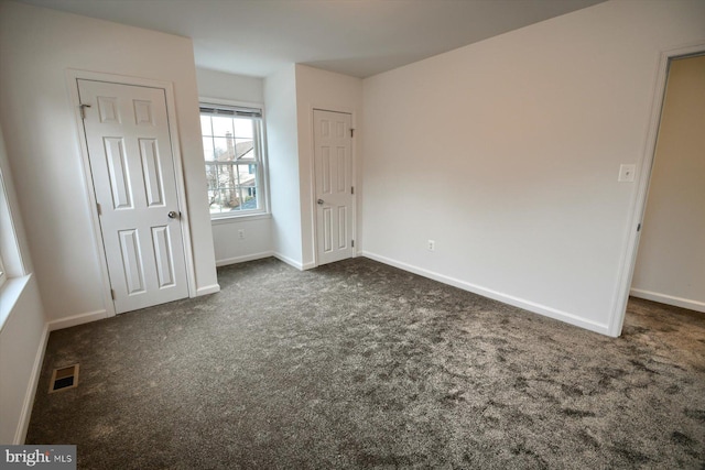 unfurnished bedroom with dark carpet