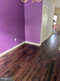 empty room with dark hardwood / wood-style floors and an inviting chandelier