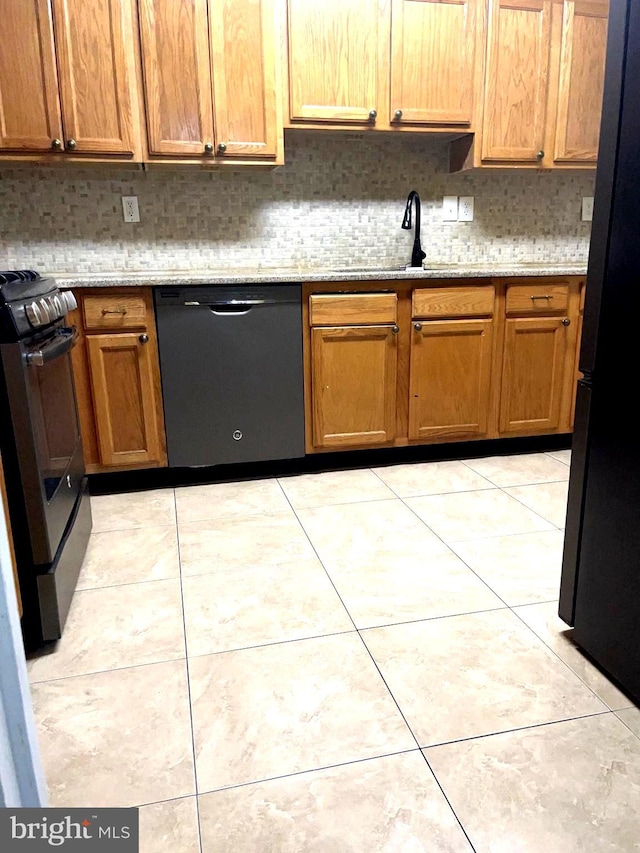 kitchen with light tile patterned flooring, decorative backsplash, sink, and black appliances