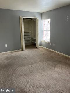 unfurnished bedroom with carpet flooring and a closet