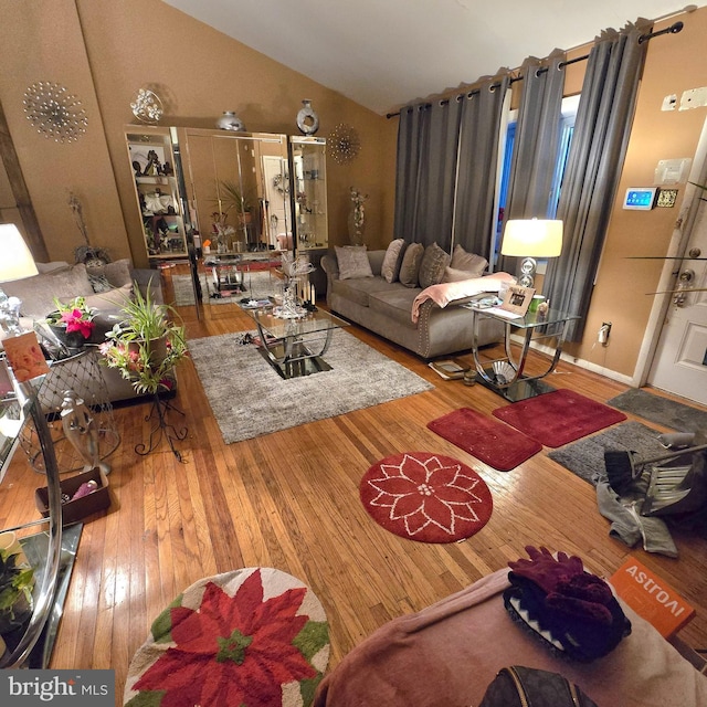 living room featuring vaulted ceiling and hardwood / wood-style flooring