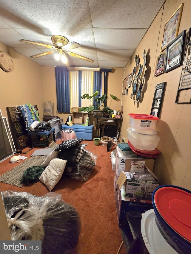 bedroom featuring ceiling fan, a drop ceiling, and carpet flooring