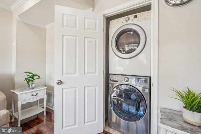 laundry area featuring dark hardwood / wood-style floors, stacked washer and dryer, and ornamental molding