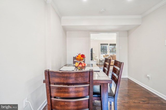 dining space with dark wood-type flooring and ornamental molding