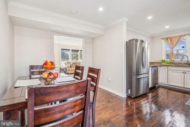 dining room featuring sink, ornamental molding, and dark hardwood / wood-style flooring