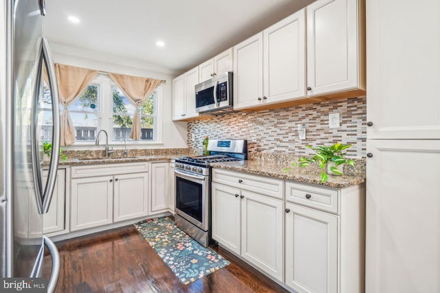 kitchen featuring light stone countertops, sink, white cabinets, stainless steel appliances, and dark hardwood / wood-style floors