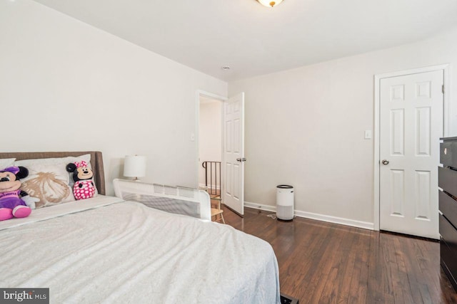 bedroom with dark hardwood / wood-style floors