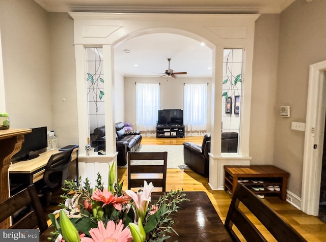 living room featuring hardwood / wood-style floors, ceiling fan, and ornamental molding