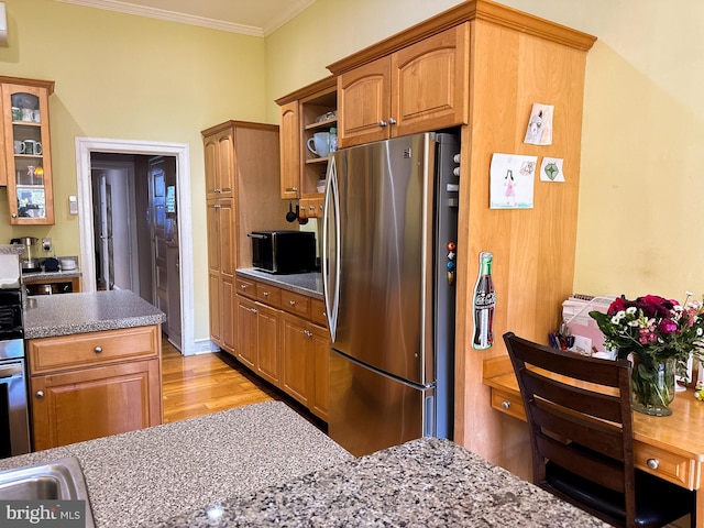 kitchen with stainless steel fridge, light hardwood / wood-style floors, and crown molding