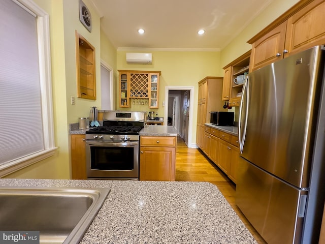 kitchen featuring light wood-type flooring, stainless steel appliances, a wall mounted AC, and ornamental molding