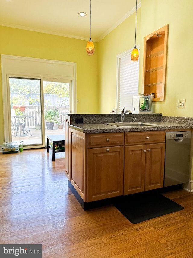 kitchen with pendant lighting, dishwasher, crown molding, sink, and light wood-type flooring