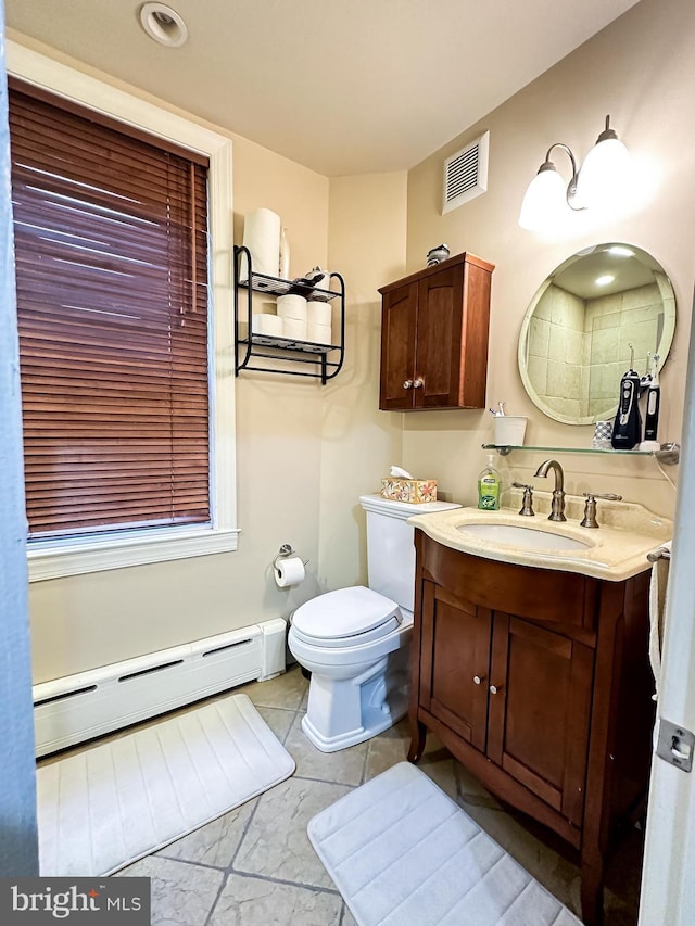 bathroom featuring tile patterned floors, vanity, toilet, and baseboard heating