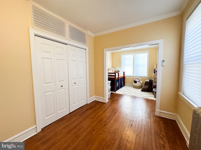 corridor featuring dark wood-type flooring and ornamental molding