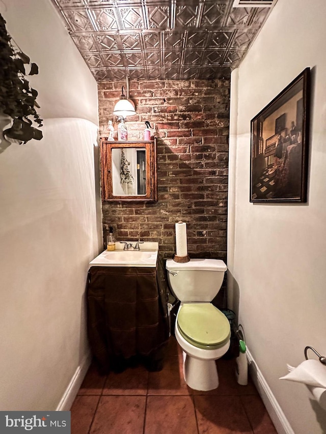 bathroom with toilet, vanity, and tile patterned floors