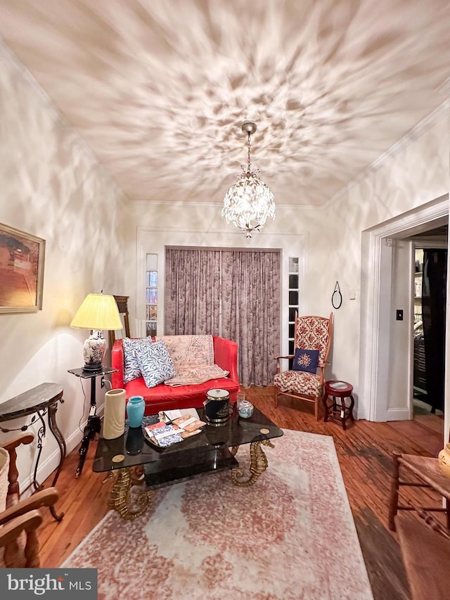 sitting room with hardwood / wood-style floors and a notable chandelier