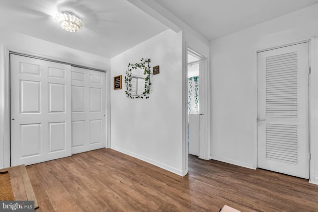 unfurnished bedroom featuring two closets and hardwood / wood-style floors