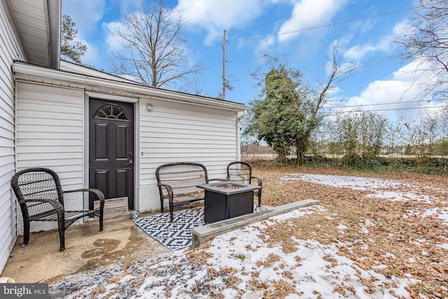 snow covered patio featuring a fire pit