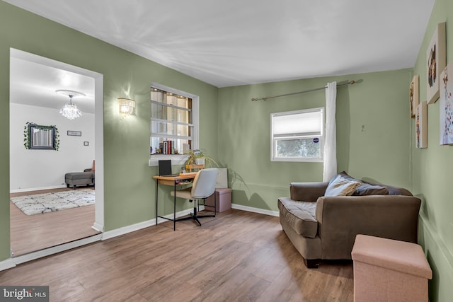 office with hardwood / wood-style flooring and a notable chandelier