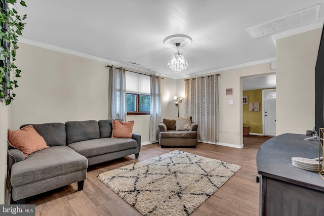 living room featuring hardwood / wood-style flooring, crown molding, and a chandelier