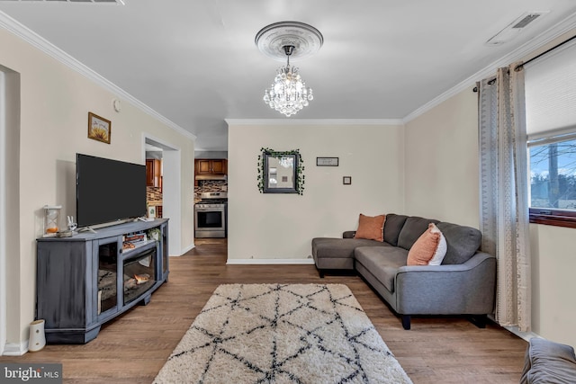 living room with a chandelier, ornamental molding, and wood-type flooring