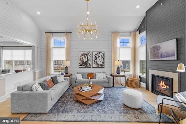 living room featuring a chandelier, high vaulted ceiling, and light hardwood / wood-style flooring