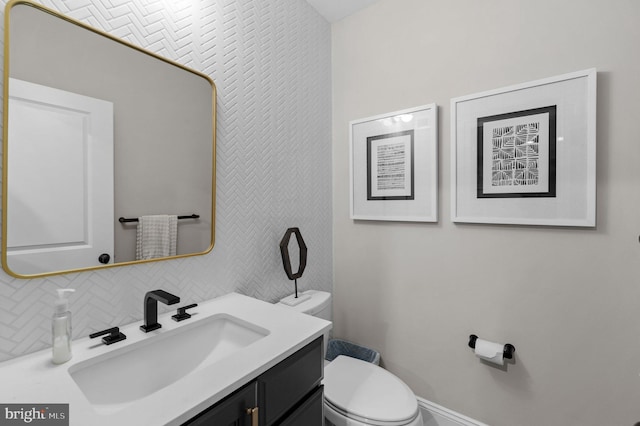 bathroom featuring vanity, decorative backsplash, and toilet