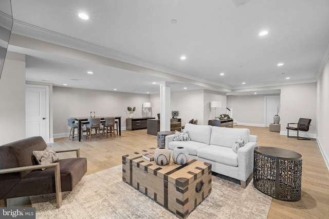 living room with crown molding and light hardwood / wood-style floors