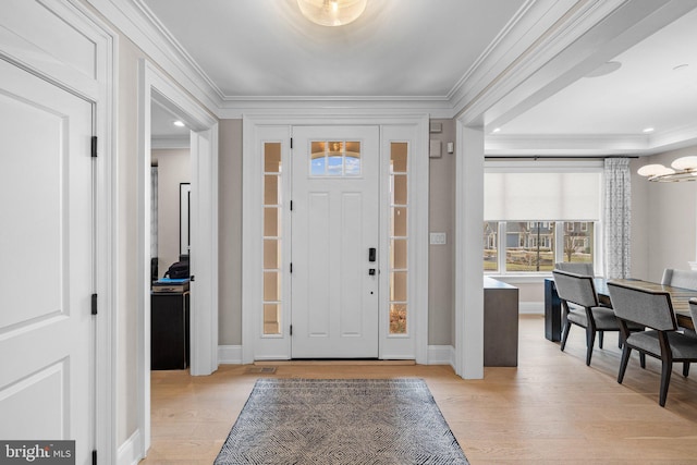 entrance foyer featuring crown molding and light hardwood / wood-style floors