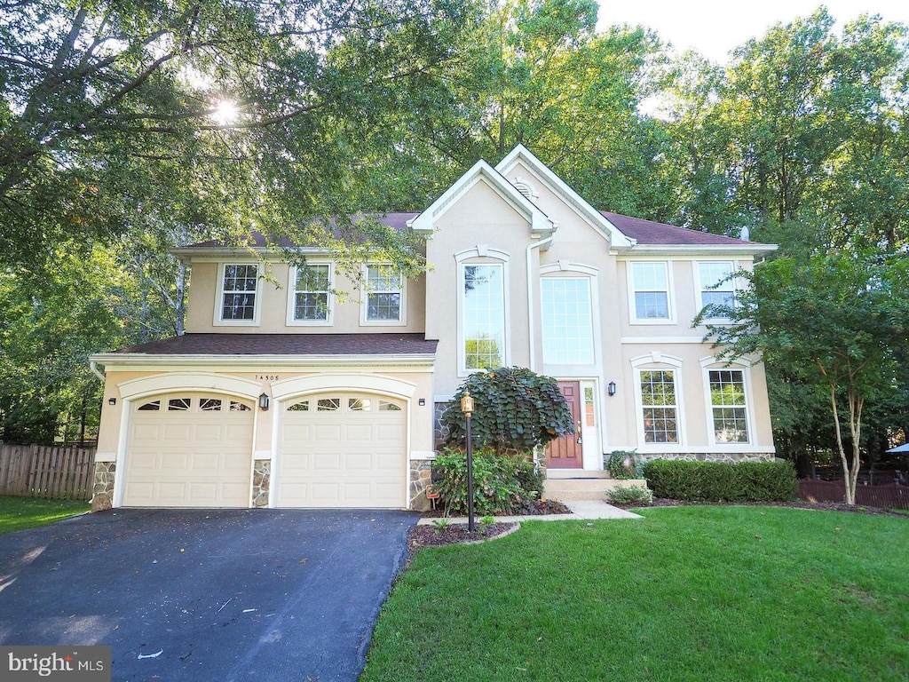 view of front of house with a garage and a front lawn