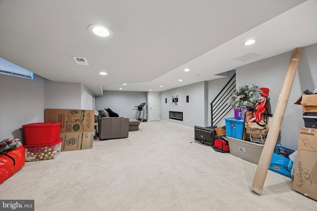 interior space featuring carpet floors, visible vents, a glass covered fireplace, and recessed lighting