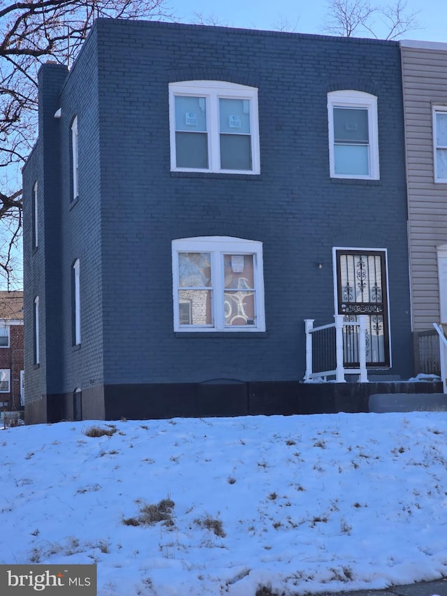 view of snow covered rear of property