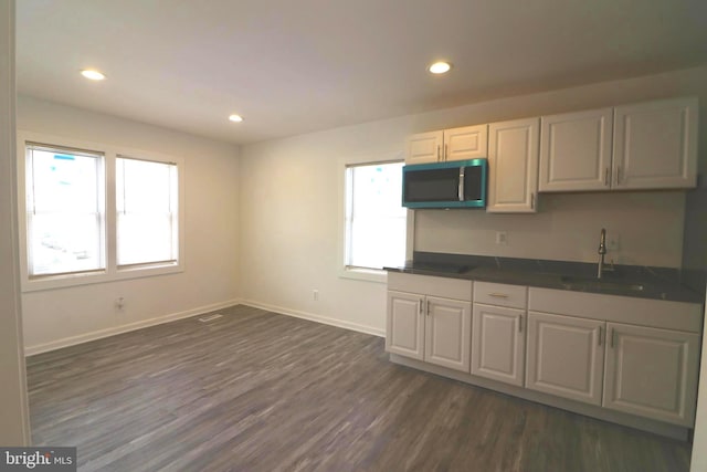 kitchen featuring white cabinetry, plenty of natural light, sink, and dark wood-type flooring