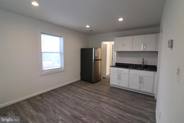 kitchen featuring white cabinetry, sink, stainless steel fridge, and dark hardwood / wood-style flooring