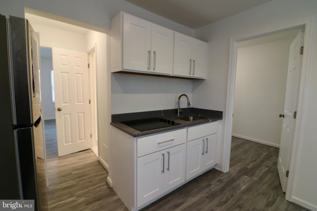 kitchen featuring white cabinetry, sink, stainless steel fridge, and dark hardwood / wood-style flooring