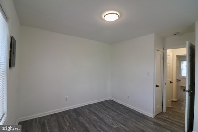 unfurnished room with dark wood-type flooring