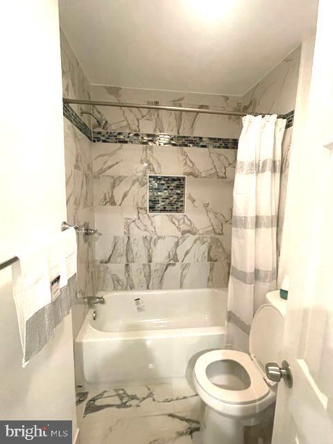 bathroom with toilet and shower / bath combo