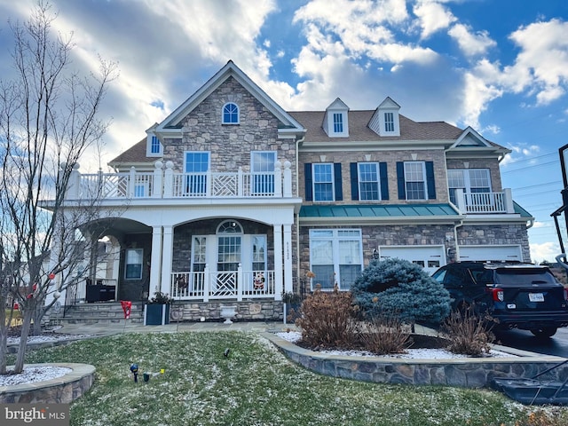 townhome / multi-family property with covered porch, a front yard, a balcony, and a garage