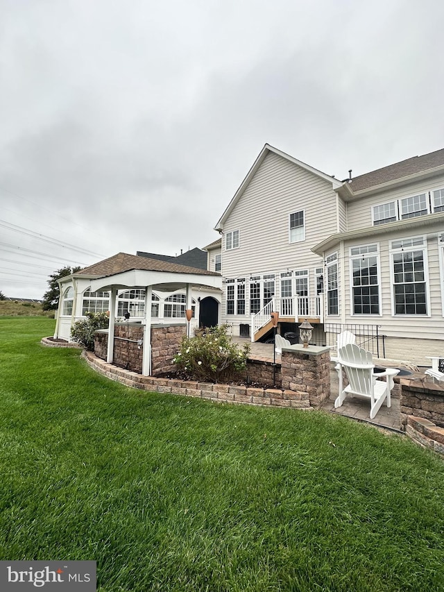 back of house featuring a patio area and a lawn